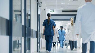 hospital hallway with many medical professionals walking through it