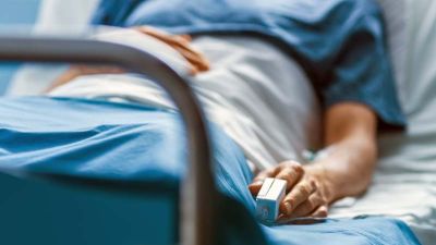 male patient in a hospital bed with his vitals tracked